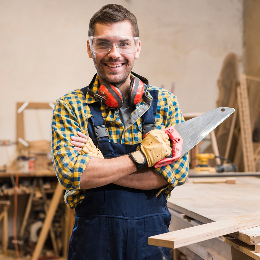 portrait-smiling-male-carpenter-holding-handsaw-looking-camera(1)